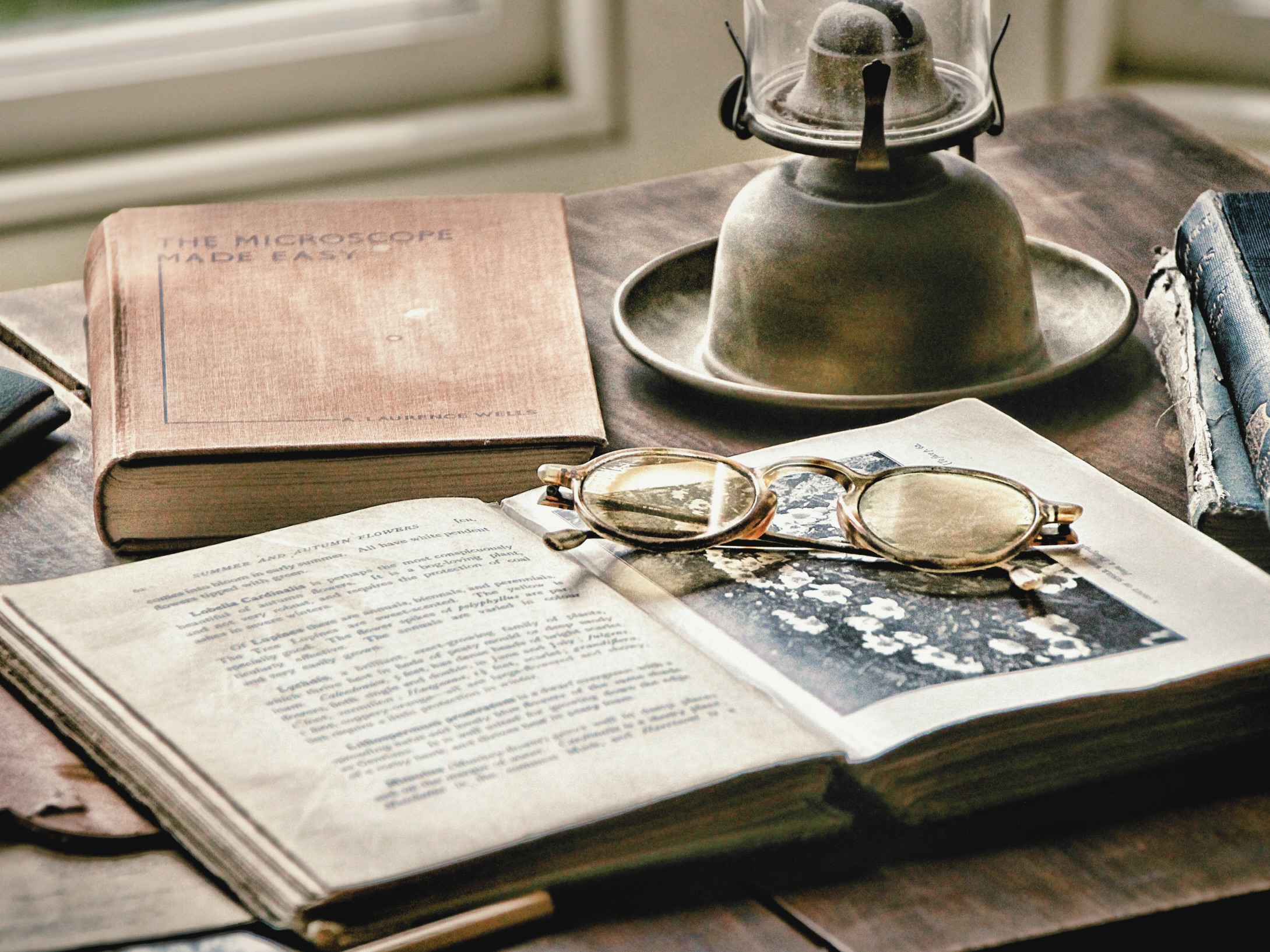 Schreibtisch mit Buch und Brille symbolisiert Lernen, entdecken, Wissen, Weisheit